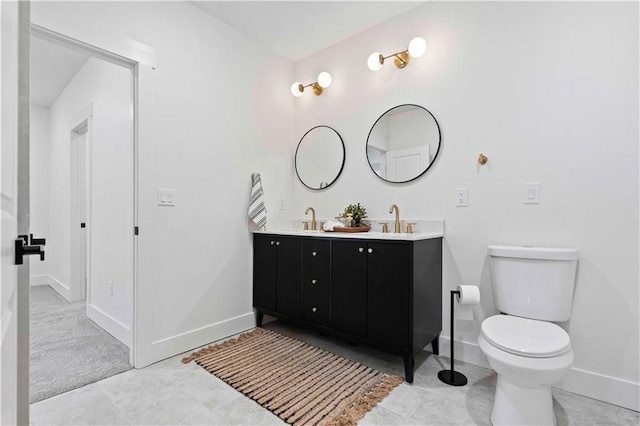 full bathroom with double vanity, toilet, baseboards, and a sink