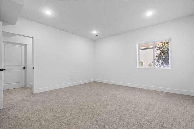 unfurnished room featuring recessed lighting, baseboards, and light carpet