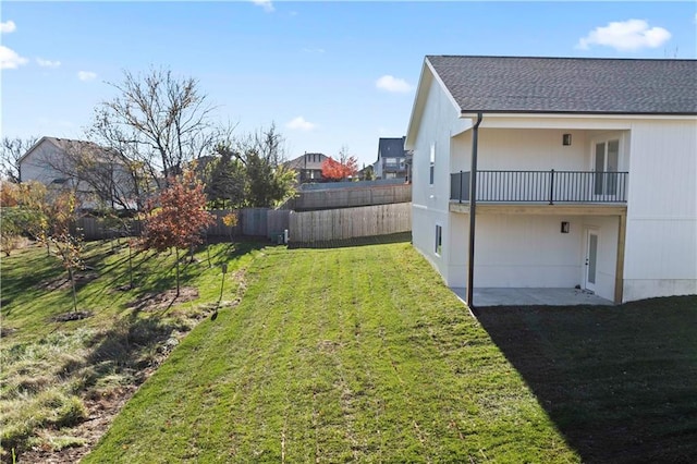 view of yard with a balcony and fence