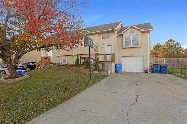 view of front of property with a front lawn, fence, concrete driveway, stucco siding, and an attached garage