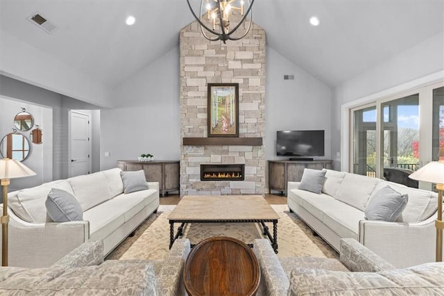 living room featuring a notable chandelier, a stone fireplace, light hardwood / wood-style flooring, and high vaulted ceiling