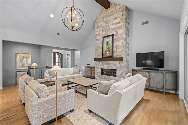 living room featuring light hardwood / wood-style flooring, high vaulted ceiling, a fireplace, beamed ceiling, and a chandelier