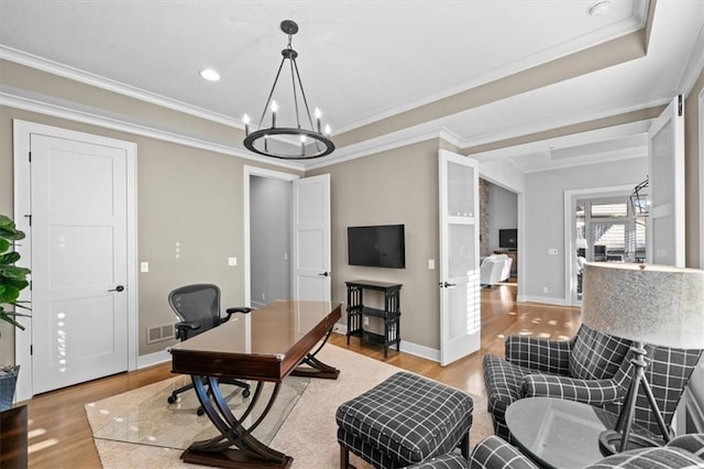 office with an inviting chandelier, crown molding, and light wood-type flooring