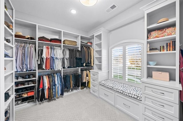 walk in closet featuring light colored carpet