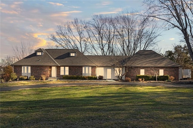 view of front of home with brick siding and a front lawn