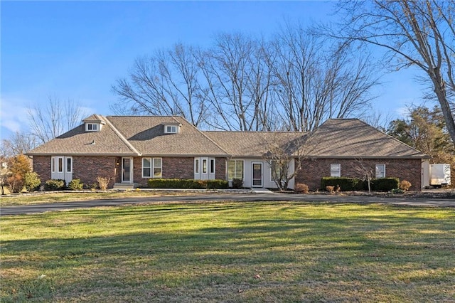 ranch-style house featuring a front yard and brick siding