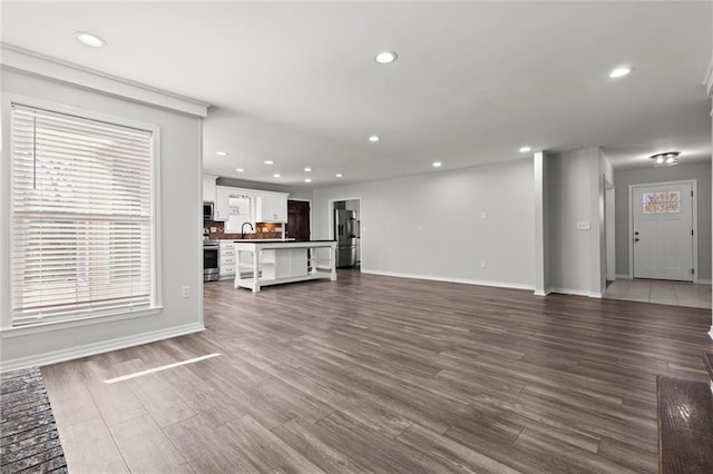 unfurnished living room with dark wood finished floors and recessed lighting