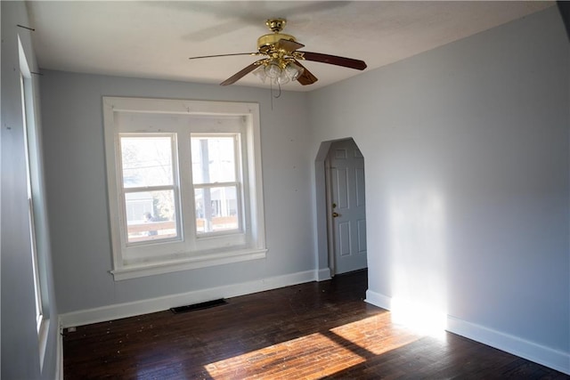 empty room featuring ceiling fan and dark hardwood / wood-style flooring