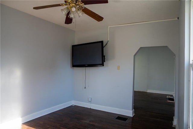 spare room with dark hardwood / wood-style flooring and ceiling fan