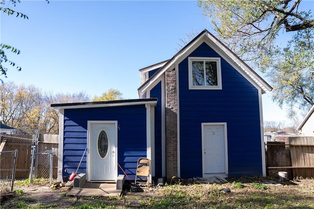 rear view of house featuring an outdoor structure