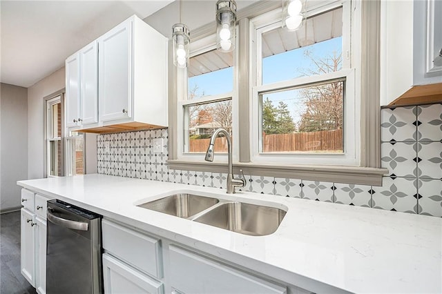 kitchen with decorative backsplash, white cabinetry, sink, and dishwasher