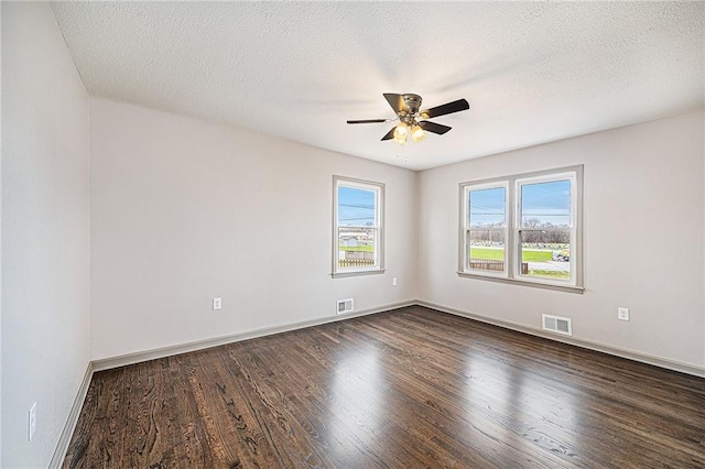 empty room featuring dark hardwood / wood-style flooring, a textured ceiling, and ceiling fan