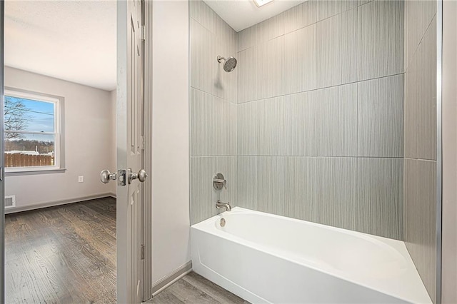 bathroom with wood-type flooring and tiled shower / bath combo