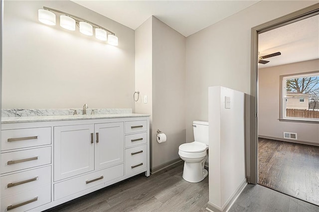 bathroom with ceiling fan, hardwood / wood-style floors, vanity, and toilet