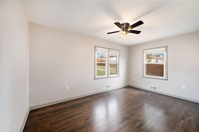 spare room with plenty of natural light, dark wood-type flooring, and ceiling fan