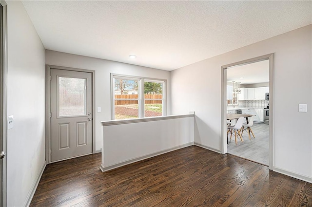 spare room featuring a textured ceiling and dark hardwood / wood-style floors