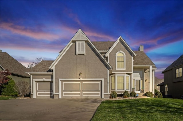 view of front of property featuring a garage and a lawn