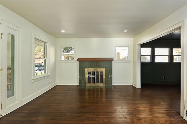 unfurnished living room featuring dark hardwood / wood-style flooring and a tile fireplace