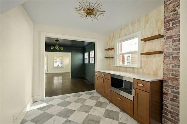 kitchen featuring stainless steel microwave, light hardwood / wood-style floors, and decorative light fixtures