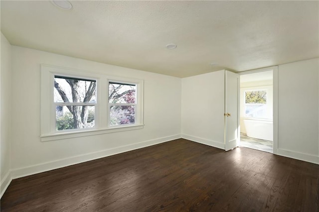 unfurnished room with dark hardwood / wood-style flooring