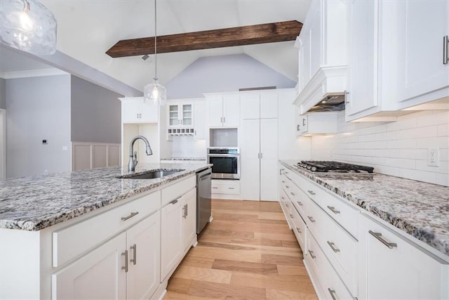 kitchen with stainless steel appliances, sink, decorative light fixtures, white cabinets, and vaulted ceiling with beams