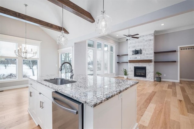 kitchen featuring white cabinetry, sink, stainless steel dishwasher, and decorative light fixtures