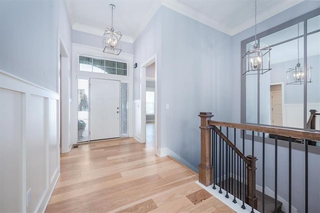 foyer entrance featuring light hardwood / wood-style floors and crown molding