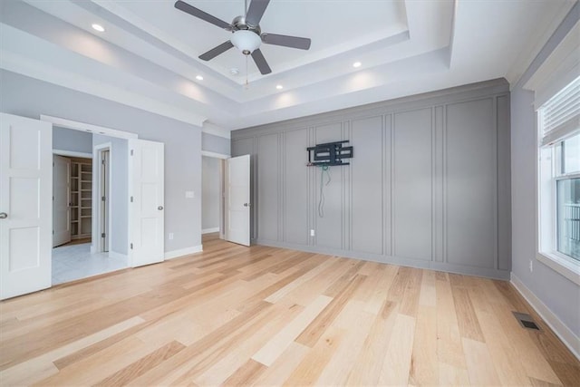 unfurnished bedroom featuring light hardwood / wood-style flooring and a tray ceiling