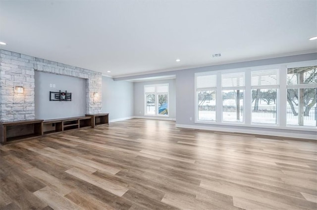 unfurnished living room with crown molding and light hardwood / wood-style flooring