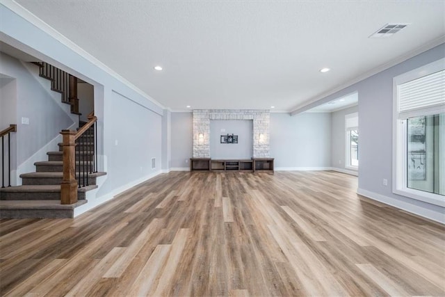 unfurnished living room featuring light wood-type flooring and ornamental molding