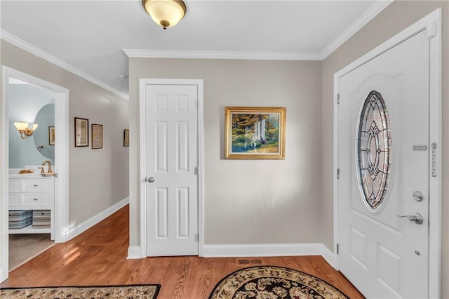 entrance foyer with wood-type flooring and crown molding