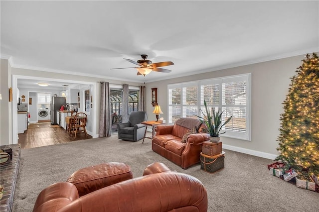 carpeted living room featuring washer / dryer, ceiling fan, and ornamental molding