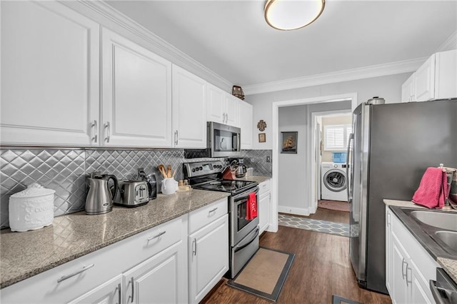 kitchen with white cabinets, appliances with stainless steel finishes, dark wood-type flooring, and washer / dryer