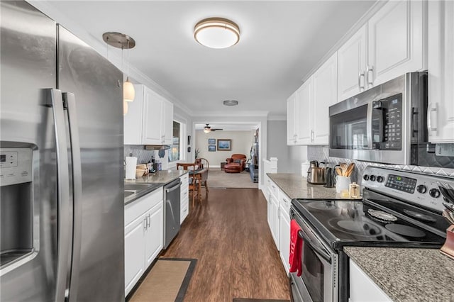 kitchen with dark wood-type flooring, stainless steel appliances, tasteful backsplash, pendant lighting, and white cabinets