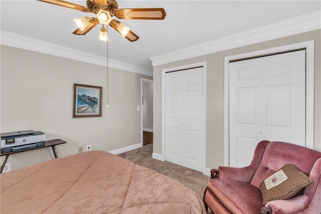 carpeted bedroom featuring ceiling fan, two closets, and ornamental molding