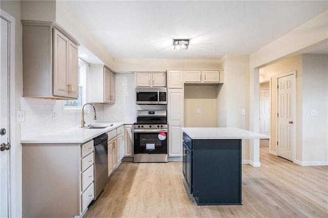 kitchen featuring sink, light hardwood / wood-style flooring, appliances with stainless steel finishes, a center island, and decorative backsplash