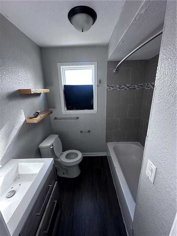 full bathroom with vanity, wood-type flooring, tiled shower / bath combo, and toilet