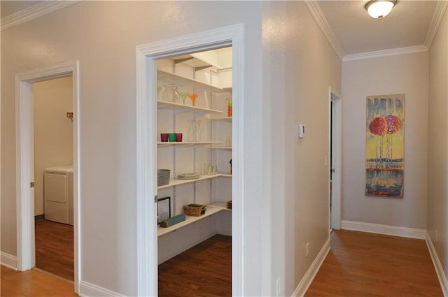 hallway featuring ornamental molding, washer / dryer, and dark wood-type flooring