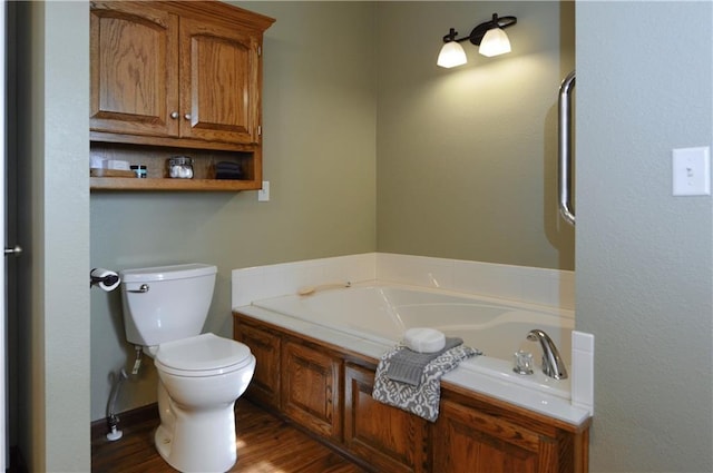 bathroom with a tub to relax in, hardwood / wood-style floors, and toilet