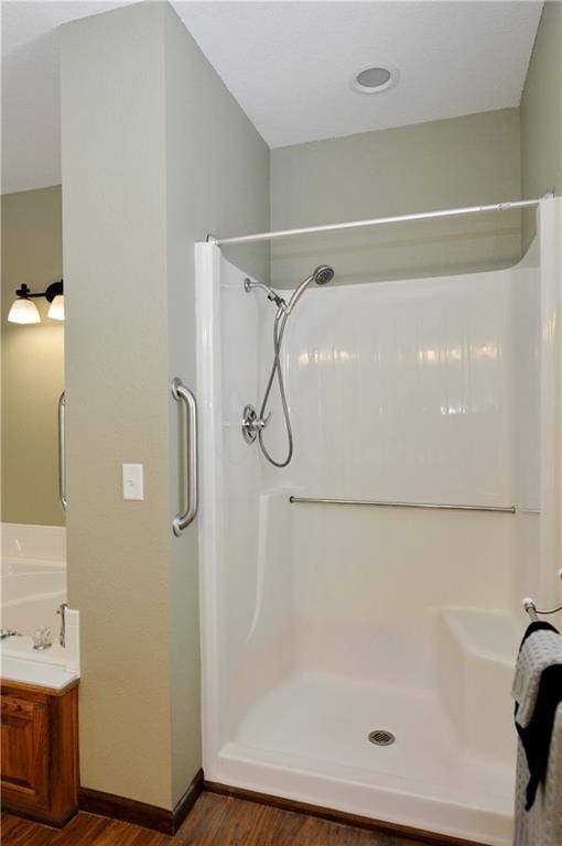 bathroom with vanity, hardwood / wood-style flooring, and a shower