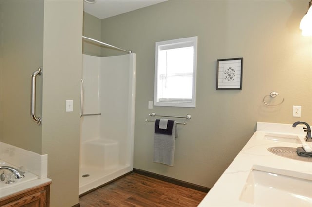 bathroom with a shower, hardwood / wood-style floors, and vanity