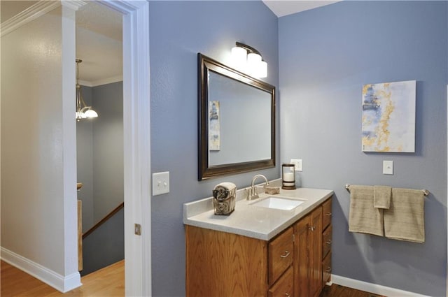 bathroom with crown molding, hardwood / wood-style floors, and vanity