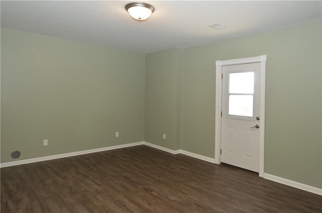 empty room with dark hardwood / wood-style flooring