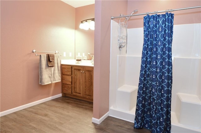 bathroom featuring hardwood / wood-style flooring, vanity, and curtained shower