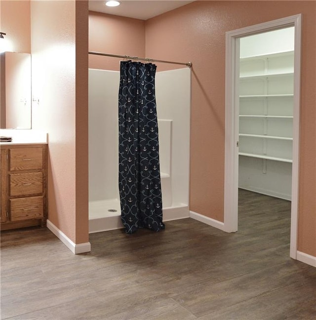 bathroom with hardwood / wood-style flooring, vanity, and a shower with curtain