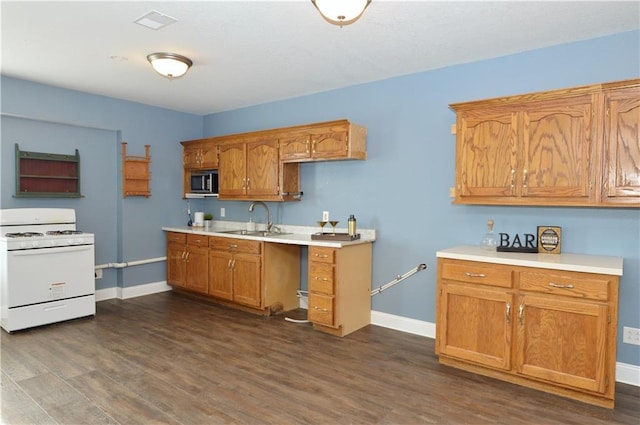 kitchen featuring dark hardwood / wood-style flooring, white gas range, and sink