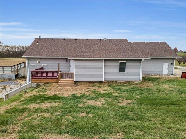 rear view of house with a wooden deck and a yard