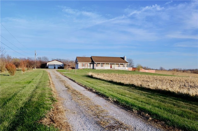 exterior space featuring a rural view, a garage, and a front lawn