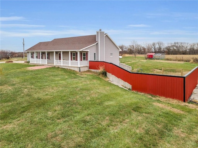 rear view of house with a lawn and covered porch