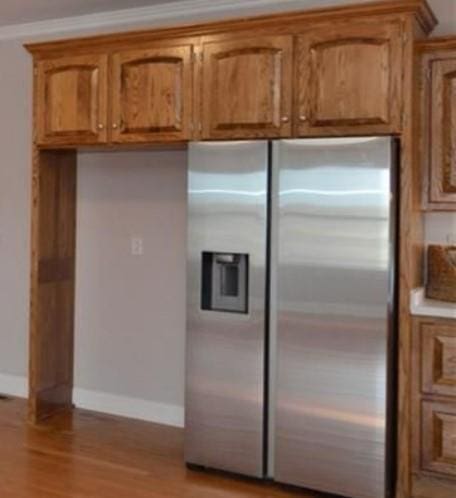 kitchen featuring stainless steel fridge with ice dispenser and light hardwood / wood-style flooring